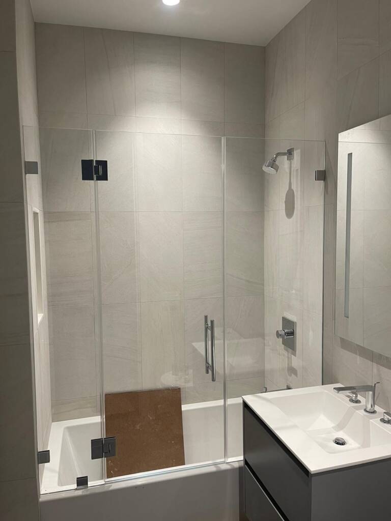 Custom frameless shower door with matching hardware in a Manhattan apartment