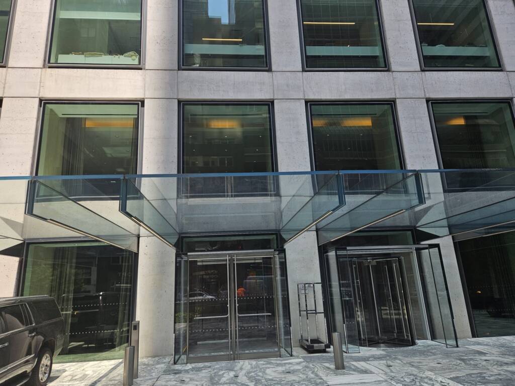 Glass Canopies in NYC: Entrance Canopies for Storefronts, Hotels & Offices 1 Suspended glass canopy over a commercial building entrance in New York City