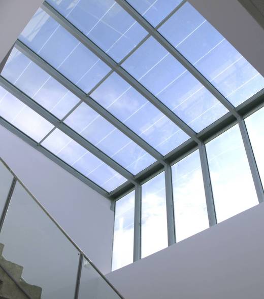 Interior view of a sloped residential glass roof and overhead glazing system